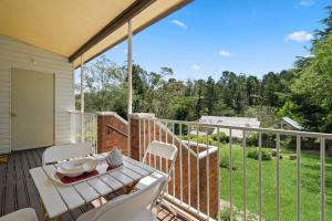 a patio with a table and chairs on a balcony at Misty Pines in Leura