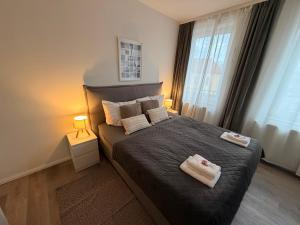 a bedroom with a bed with two towels on it at OMNI Rooms - Oranienburg in Oranienburg