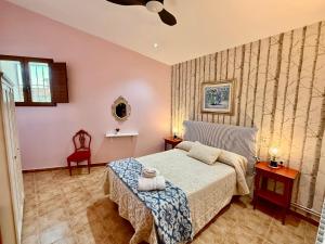 a bedroom with a bed and two tables and a chair at RAPIA Casa Beig 5 in Moratalla +11 photos