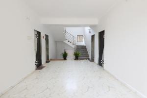 an empty hallway with stairs in a white building at FabHotel Sharvi in Mahabaleshwar