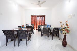 a dining room with chairs and a table with flowers at FabHotel Sharvi in Mahabaleshwar