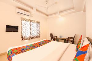 a white bedroom with a bed and a tv at FabHotel Sharvi in Mahabaleshwar +33 photos
