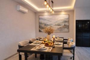 a dining room with a table and a painting at Vantara Villa with Activity Ice Bath in Chiang Mai