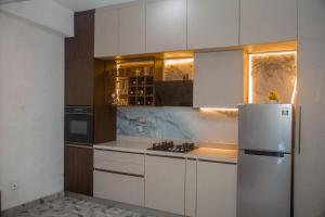 a kitchen with white cabinets and a refrigerator at Celenika Resort in Kandy