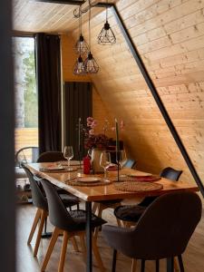 a dining room with a table and chairs at La Știubei Cabin in Mărişel