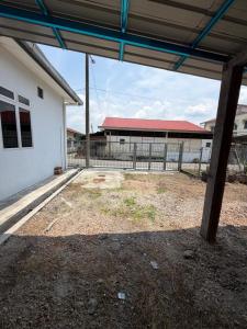 an empty yard in front of a white building at Teratak Bonda in Temuh