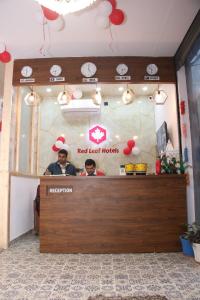 two people standing at the counter of a red heart hooks restaurant at Red Leaf Hotel in Māler Kotla