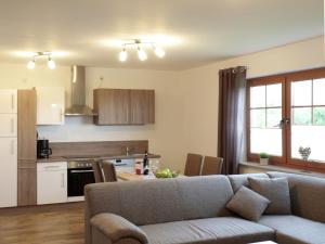 a living room with a couch and a kitchen at Holiday flat in the Sauerland with terrace in Medebach