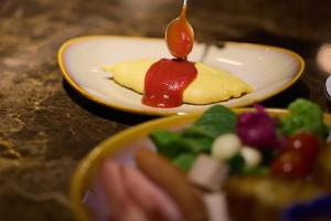 a plate of food with a desert with sauce on it at Kyoto Century Hotel in Kyoto