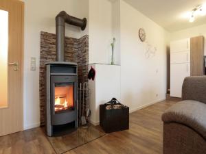 a living room with a fireplace and a couch at Holiday flat in the Sauerland with terrace in Medebach