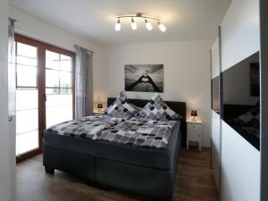 sypialnia z łóżkiem z kocem szachowym w obiekcie Holiday flat in the Sauerland with terrace w mieście Medebach
