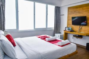 a bedroom with a large white bed with windows at Chill Berg Resort - Bodimettu in Theni