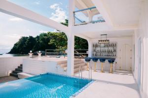 a house with a swimming pool and a bar at Ezrah coastal boutique hotel el nido in El Nido