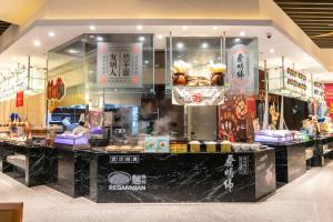 a restaurant with a counter with food on it at Shangri-La Wuhan, Interchange hub of three metro lines,Adjacent to the MixC in Wuhan