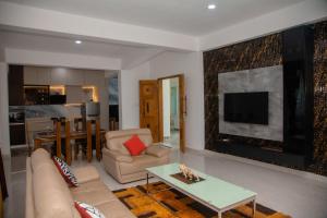 a living room with a couch and a tv at Celenika Resort in Kandy