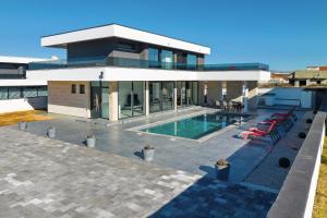 ein großes Haus mit einem davorliegenden Swimmingpool in der Unterkunft Astur in Zadar
