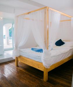 a bed with a mosquito net on top of it at Ezrah coastal boutique hotel el nido in El Nido