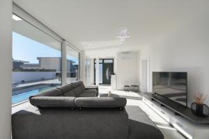 ein Wohnzimmer mit Sofa und Flachbildfernseher in der Unterkunft Astur in Zadar