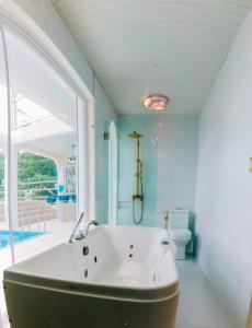 a bathroom with a large window and a bath tub at Ezrah coastal boutique hotel el nido in El Nido