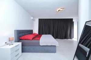 ein Schlafzimmer mit einem Bett mit roten Kissen in der Unterkunft Astur in Zadar + 45 Fotos