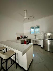 a kitchen with a table and chairs and a sink at Paje staycation apartment in Paje