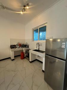 a kitchen with a stainless steel refrigerator and a sink at Paje staycation apartment in Paje