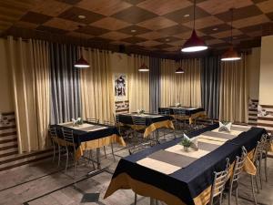 a dining room with tables and chairs and curtains at Hotel Buro The Gate in Kalpa