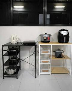 a kitchen with two tables with pots and pans at Ben & Ben 2 in Cebu