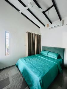 a bedroom with a large bed with blue sheets at The Galene Villa By Celestial Ceylon in Negombo