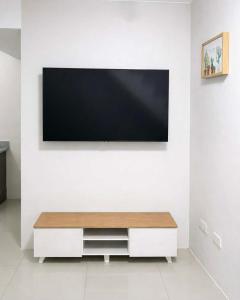 a living room with a tv on a white wall at Ben & Ben 2 in Cebu