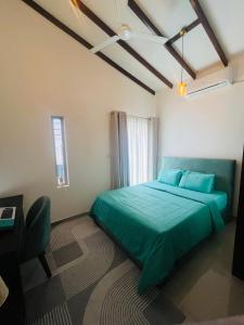a bedroom with a green bed and a desk at The Galene Villa By Celestial Ceylon in Negombo