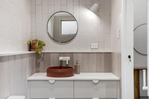 a bathroom with a sink and a mirror at The Ausly Architectural Coastal Retreat with pool pet friendly in Aldinga Beach