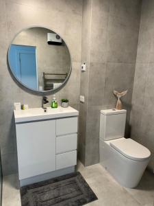 a bathroom with a white toilet and a mirror at Bayview Apartment in Timaru +25 photos