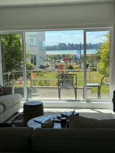 a living room with a large window looking out at the water at Bayview Apartment in Timaru