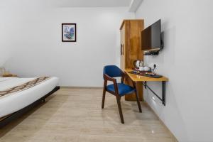 a bedroom with a desk and a bed and a tv at Rooms To Go - Indian Guest only in Vadodara