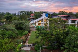an aerial view of a house in the trees at Gauri Villa by ELIVAAS With Pool, Lounge, Garden & Bathtub With 360 Panoramic Hill Views Near Waterfalls in Kasāra