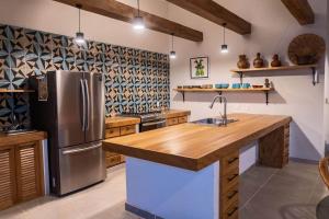 a kitchen with a stainless steel refrigerator and wooden counter tops at Casa Rita! Relaxing two bedroom getaway! in Puerto Escondido
