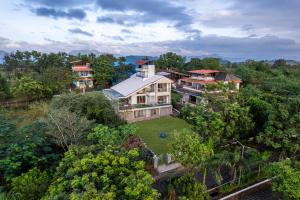 an aerial view of a house in the forest at Gauri Villa by ELIVAAS With Pool, Lounge, Garden & Bathtub With 360 Panoramic Hill Views Near Waterfalls in Kasāra