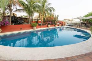a large swimming pool with palm trees in a resort at Casa Bella Brisa in Puerto Escondido