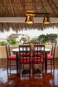 a dining room table and chairs with a view of the ocean at Casa Bella Brisa in Puerto Escondido