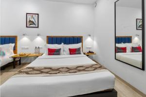 a bedroom with two beds with red and white pillows at Rooms To Go - Indian Guest only in Vadodara