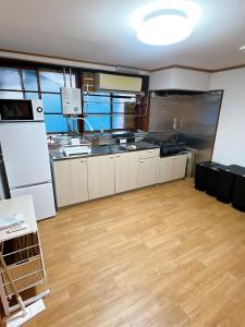 a large kitchen with stainless steel appliances and wooden floors at 8 Guests Entire Private House in Gifu +14 photos