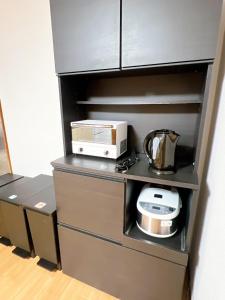 a kitchen with a microwave and a toaster oven on a shelf at 8 Guests Entire Private House in Gifu