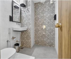 a bathroom with a toilet and a tiled wall at Rooms To Go - Indian Guest only in Vadodara +101 photos