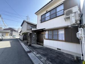 a white building with a balcony on a street at 8 Guests Entire Private House in Gifu
