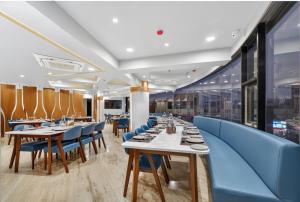 a dining room with tables and blue chairs at Rooms To Go - Indian Guest only in Vadodara