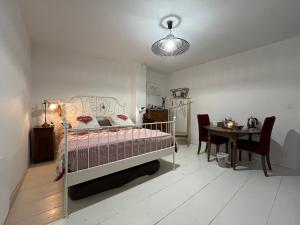 a bedroom with a bed and a table and a dining room at La Cocotte Rousse, ses Petits Déjeuners et sa Table in Parves