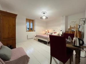 a living room with a bed and a dining room table at La Cocotte Rousse, ses Petits Déjeuners et sa Table in Parves