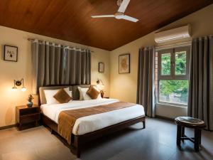 a bedroom with a large bed and a window at Hotel Marigold Mount Abu - With Swimming Pool in Mount Ābu +35 photos