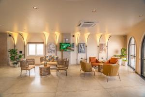 a living room with chairs and tables and a couch at Aura Inn & Suites in Mysore
